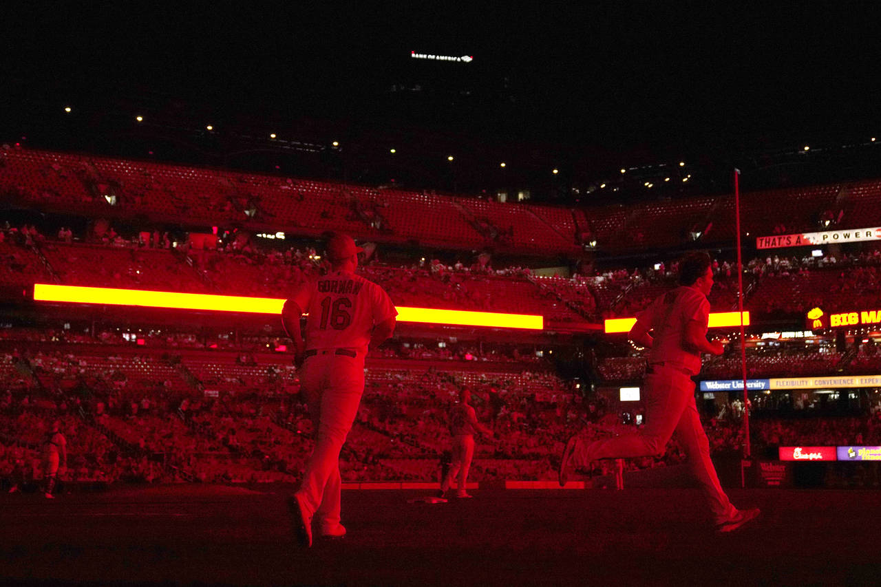 The field is illuminated only in red light from the scoreboard after the lights inside Busch Stadiu...