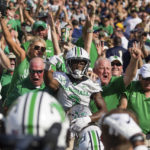 
              Marshall defensive back Steven Gilmore (3) jumps into the stands after returning an interception for a score against Notre Dame during an NCAA college football game Saturday, Sept. 10, 2022, in South Bend, Ind. Marshall won 26-21. (Sholten Singer/The Herald-Dispatch via AP)
            