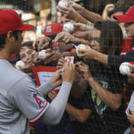 
              Los Angeles Angels' Shohei Ohtani signs autographs before a baseball game against the Cleveland Guardians, Monday, Sept. 12, 2022, in Cleveland. (AP Photo/David Dermer)
            