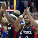 
              Elie Okobo of France, right, applaudes after the the Eurobasket semi final basketball match between Poland and France in Berlin, Germany, Friday, Sept. 16, 2022. France defeated Poland by 95-54. (AP Photo/Michael Sohn)
            