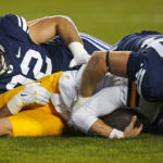 
              BYU's John Nelson (94) and Tyler Batty, left, sack Wyoming quarterback Andrew Peasley during the first half of an NCAA college football game Saturday, Sept. 24, 2022, in Provo, Utah. (AP Photo/Rick Bowmer)
            