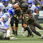 
              Oregon running back Mar'Keise Irving makes a cut as he rushes against BYU defensive back Ammon Hannemann and linebacker Keenan Pili during the first half of an NCAA college football game, Saturday, Sept. 17, 2022, in Eugene, Ore. (AP Photo/Andy Nelson)
            