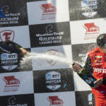 
              Chip Ganassi Racing driver Álex Palou, of Spain, left, sprays champagne on Team Penske driver Will Power, of Australia, after Palou won the IndyCar season finale auto race at Laguna Seca Raceway on Sunday, Sept. 11, 2022, Monterey, Calif. Power won third place. (AP Photo/Nic Coury)
            