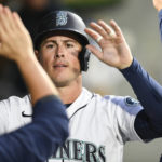 
              Seattle Mariners' Dylan Moore high fives his teammates in the dugout after scoring a run off of Eugenio Suarez' double against the Texas Rangers during the first inning of a baseball game, Wednesday, Sept. 28, 2022, in Seattle. (AP Photo/Caean Couto)
            