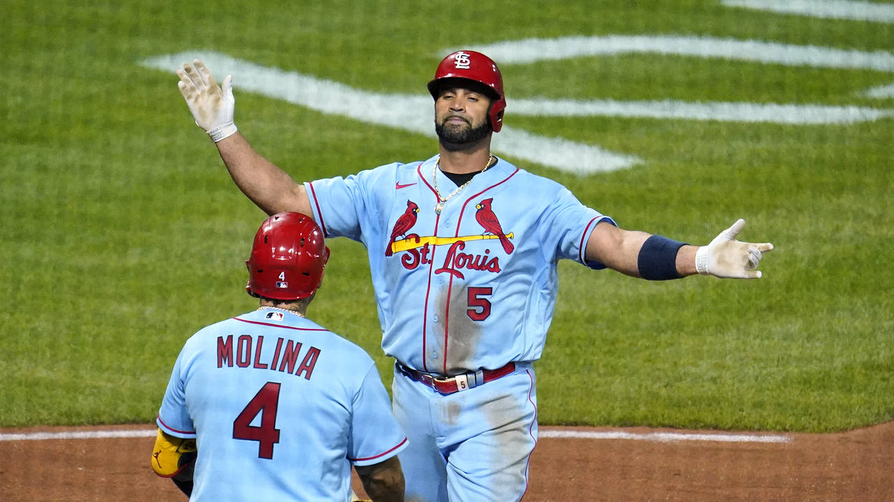 St. Louis Cardinals' Albert Pujols (5) is greeted by Yadier Molina (4) after hitting a two-run home...
