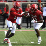 
              Louisville quarterback Malik Cunningham (3) hands the ball off to running back Trevion Cooley (23) during the second half of an NCAA college football game against South Florida in Louisville, Ky., Saturday, Sept. 24, 2022. Louisville won 41-3. (AP Photo/Timothy D. Easley)
            