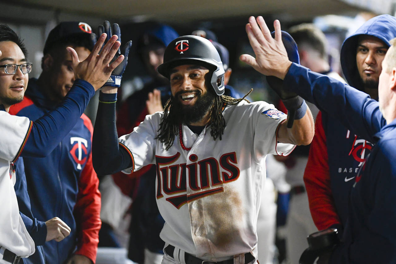 Minnesota Twins' Billy Hamilton is congratulated in the dugout after he scored against the Chicago ...
