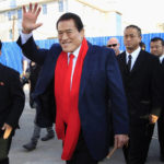 
              CORRECTS TO 1976, NOT 1979 - FILE - Japanese pro-wrestler turned politician Kanji "Antonio" Inoki waves as he arrives at the Sunan International Airport on Aug. 28, 2014, in Pyongyang, North Korea. A popular Japanese professional wrestler and lawmaker Antonio Inoki, who faced a world boxing champion Muhammad Ali in a mixed martial arts match in 1976, has died at 79. The New Japan Pro-Wrestling Co. says Inoki, who was battling an illness, died earlier Saturday, Oct. 1, 2022. (AP Photo/Jon Chol Jin, File)
            