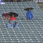 
              Fans wait out a rain delay during the fourth inning of a baseball game between the Seattle Mariners and the Cleveland Guardians in Cleveland, Sunday, Sept. 4, 2022. (AP Photo/Phil Long)
            