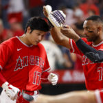
              Los Angeles Angels' Jo Adell (7) puts a cowboy hat onto Shohei Ohtani (17) while celebrating Ohtani's two-run home run during the third inning of a baseball game against the Detroit Tigers in Anaheim, Calif., Monday, Sept. 5, 2022. (AP Photo/Ringo H.W. Chiu)
            