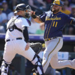 
              Milwaukee Brewers' Rowdy Tellez, right, scores on a double hit by Andrew McCutchen as Colorado Rockies catcher Brian Serven, left, looks for the throw in the fourth inning of a baseball game Monday, Sept. 5, 2022, in Denver. (AP Photo/David Zalubowski)
            