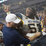 
              West Virginia defensive lineman Dante Stills (55) is pushed away from Pittsburgh players as the team leaves the field after an NCAA college football game Thursday, Sept. 1, 2022, in Pittsburgh. Pittsburgh won 38-31.(AP Photo/Keith Srakocic)
            