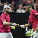 
              Team World's Jack Sock, left, and Felix Auger-Aliassime react during a match against Team Europe's Andy Murray, left, talks to Matteo Berrettini on final day of the Laver Cup tennis tournament at the O2 in London, Sunday, Sept. 25, 2022. (AP Photo/Kin Cheung)
            