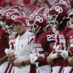 
              Oklahoma head coach Brent Venables and players link arms across the field before an NCAA college football game against Kent State, Saturday, Sept. 10, 2022, in Norman, Okla. (AP Photo/Sue Ogrocki)
            