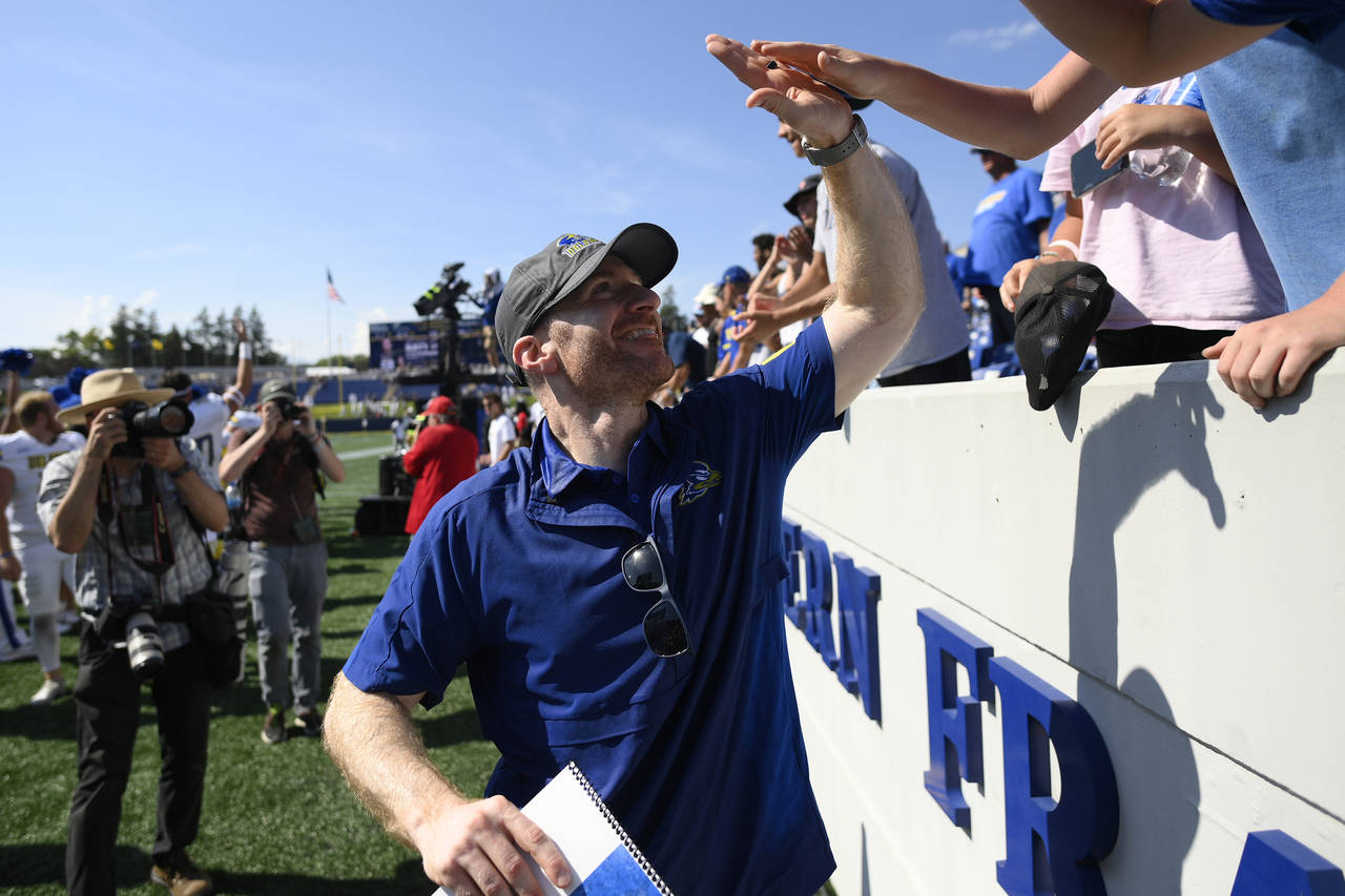 Delaware head coach Ryan Carty high fives fans after an NCAA college football game against Navy, Sa...