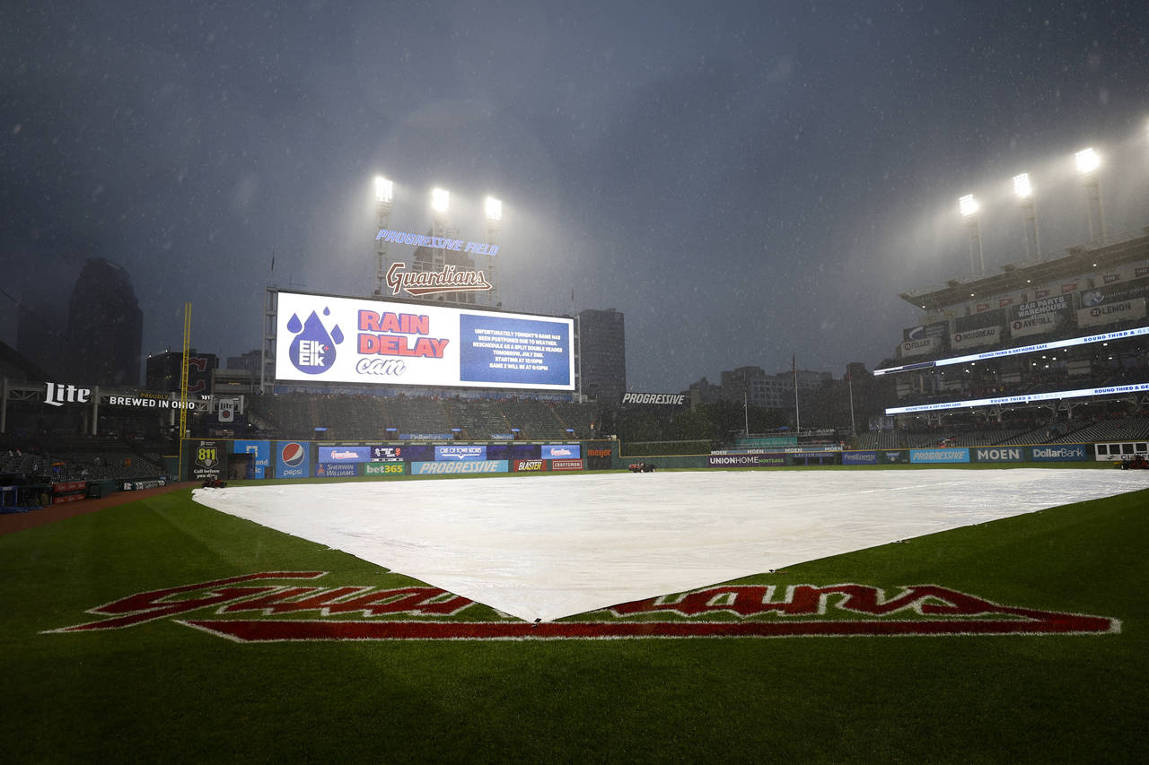 FILE - The tarp covers the infield as rain falls before a scheduled baseball game between the New Y...