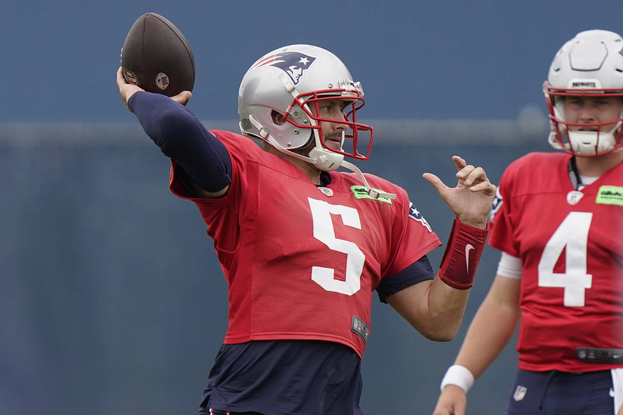 New England Patriots quarterback Brian Hoyer (5) winds up for a pass near quarterback Bailey Zappe ...