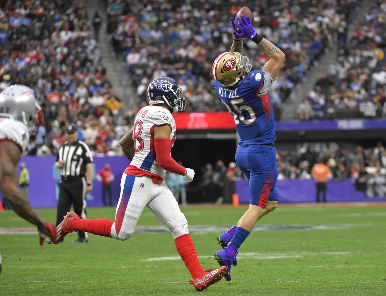 FILE - NFC tight end George Kittle, right, of the San Francisco 49ers, catches a pass in front of A...