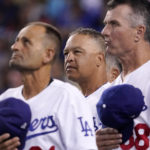 
              Los Angeles Dodgers manager Dave Roberts, center, stands with third base coach Dino Ebel, left, and coach Bob Geren as they watch a video tribute to Maury Wills prior to a baseball game against the Arizona Diamondbacks Tuesday, Sept. 20, 2022, in Los Angeles. Wills passed away on Monday. (AP Photo/Mark J. Terrill)
            