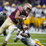 
              Florida State quarterback Jordan Travis (13) carries against LSU safety Jay Ward (5) in the second half of an NCAA college football game in New Orleans, Sunday, Sept. 4, 2022. Florida State won 24-23. (AP Photo/Gerald Herbert)
            