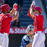 
              Los Angeles Angels' Mike Ford, left, congratulates Livan Soto for hitting a two-run home run as Seattle Mariners catcher Cal Raleigh, center below, looks away, during the seventh inning of a baseball game in Anaheim, Calif., Sunday, Sept. 18, 2022. (AP Photo/Alex Gallardo)
            