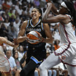 
              Chicago Sky forward Candace Parker, center, drives between Connecticut Sun guard Natisha Hiedeman, left, and Jonquel Jones, right, during Game 3 of a WNBA basketball semifinal playoff series, Sunday, Sept. 4, 2022, in Uncasville, Conn. (AP Photo/Jessica Hill)
            