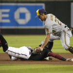 
              Arizona Diamondbacks' Josh Rojas dives into second base safely under the tag by Milwaukee Brewers shortstop Willy Adames (27) in the first inning during a baseball game, Saturday, Sept. 3, 2022, in Phoenix. (AP Photo/Rick Scuteri)
            