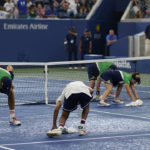 
              Court workers dry the surface after rain stopped play between Andrey Rublev, of Russia, and Cameron Norrie, of Great Britain, during the fourth round of the U.S. Open tennis championships, Monday, Sept. 5, 2022, in New York. (AP Photo/Eduardo Munoz Alvarez)
            
