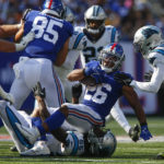 
              New York Giants' Saquon Barkley (26), center, is tackled during the second half an NFL football game Carolina Panthers, Sunday, Sept. 18, 2022, in East Rutherford, N.J. (AP Photo/John Munson)
            