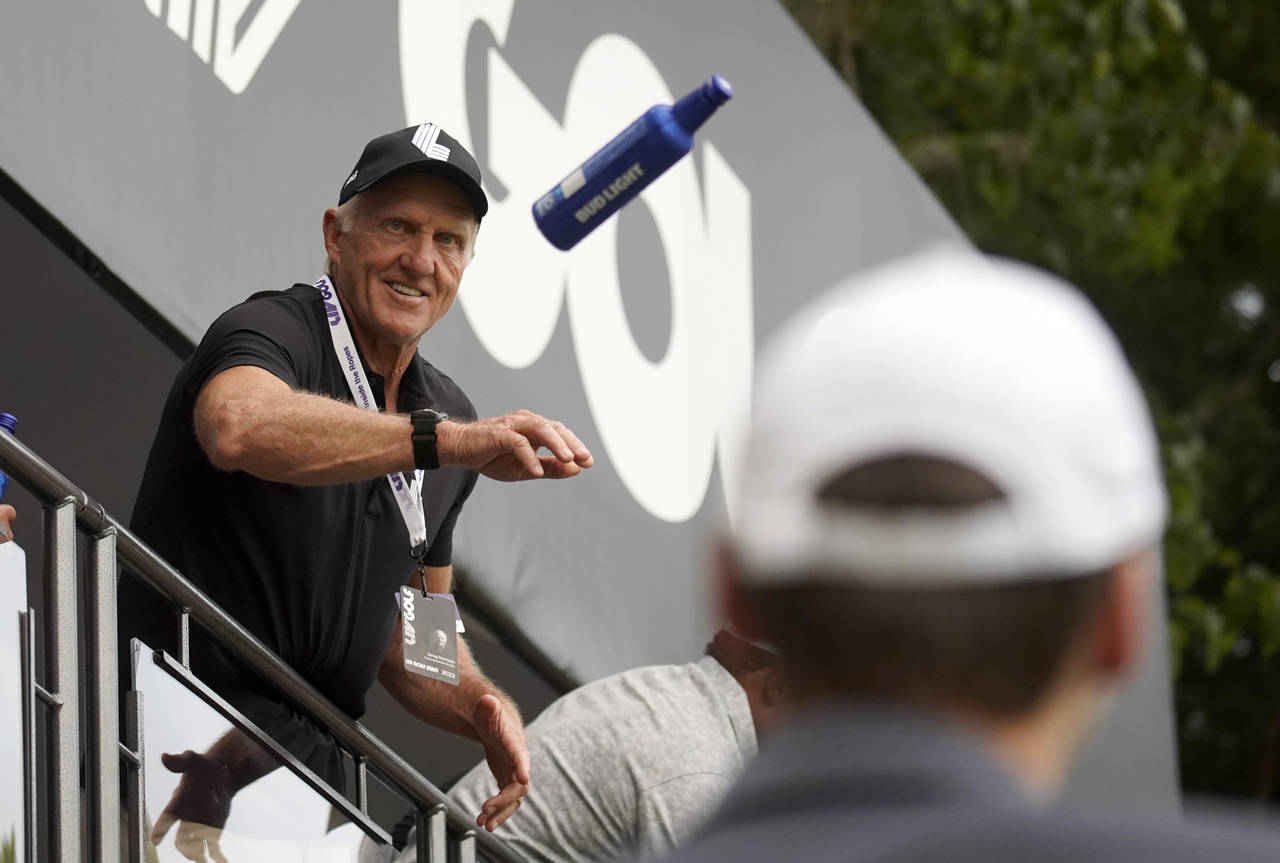 LIV Golf CEO Greg Norman tosses beer to fans on the 18th green during the final round of the LIV Go...