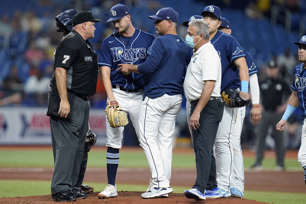 Tampa Bay Rays starting pitcher Shane McClanahan, second from left is taken out of the game against...