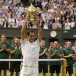 
              FILE - Switzerland's Roger Federer is applauded by ground staff as he holds the trophy after defeating Croatia's Marin Cilic to win the Men's Singles final match on day thirteen at the Wimbledon Tennis Championships in London Sunday, July 16, 2017. Federer announced Thursday, Sept.15, 2022 he is retiring from tennis. (AP Photo/Alastair Grant, File)
            