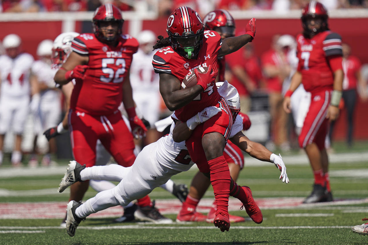 Southern Utah safety George Ramirez, rear, tackles Utah running back Chris Curry during the first h...