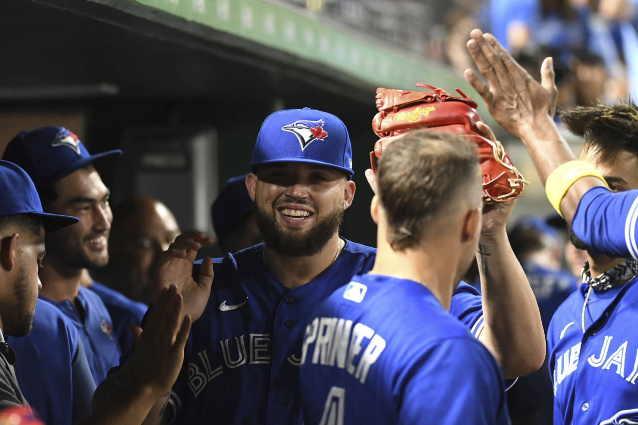 Toronto Blue Jays starter Alek Manoah, center, is greeted in the dugout after being pulled during t...