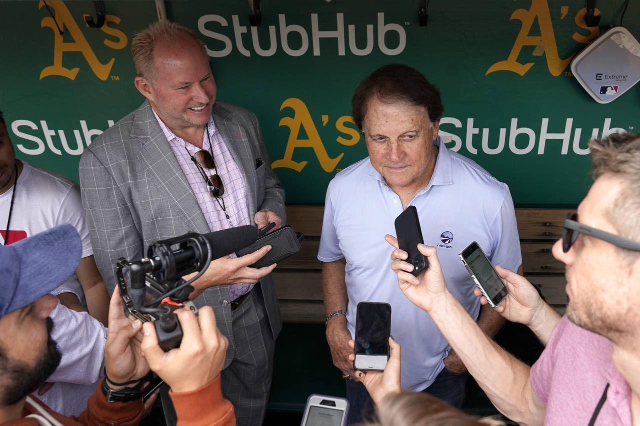 Chicago White Sox manager Tony La Russa, back right, talks to reporters in the dugout before a base...