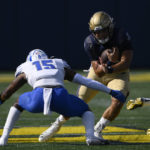 
              Navy quarterback Tai Lavatai, right, runs with the ball against Memphis defensive back Quindell Johnson (15) during the first half of an NCAA college football game, Saturday, Sept. 10, 2022, in Annapolis, Md. (AP Photo/Nick Wass)
            