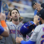 
              New York Mets' Jeff McNeil is congratulated by teammates after he and Eduardo Escobar scored on a double by Tomas Nido during the fifth inning of a baseball game against the Miami Marlins, Sunday, Sept. 11, 2022, in Miami. (AP Photo/Wilfredo Lee)
            