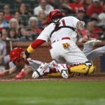 
              Cincinnati Reds' Stuart Fairchild, left, is tagged out at home plate by St. Louis Cardinals catcher Yadier Molina during the eighth inning of a baseball game Thursday, Sept. 15, 2022, in St. Louis. (AP Photo/Joe Puetz)
            
