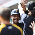 
              Pittsburgh Pirates' Ke'Bryan Hayes smiles as he high-fives teammates in the dugout after scoring a run during the ninth inning of the first game of a baseball doubleheader against the Cincinnati Reds in Cincinnati, Tuesday, Sept. 13, 2022. The Pirates won 6-1. (AP Photo/Aaron Doster)
            