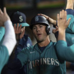
              Seattle Mariners Dylan Moore is congratulated by teammates in the dugout after he scored against the Oakland Athletics during the first inning of a baseball game Friday, Sept. 30, 2022, in Seattle. (AP Photo/Stephen Brashear)
            