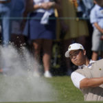 
              Tom Kim, of South Korea, hits from a bunker on the 16th hole during their foursomes match at the Presidents Cup golf tournament at the Quail Hollow Club, Saturday, Sept. 24, 2022, in Charlotte, N.C. (AP Photo/Julio Cortez)
            