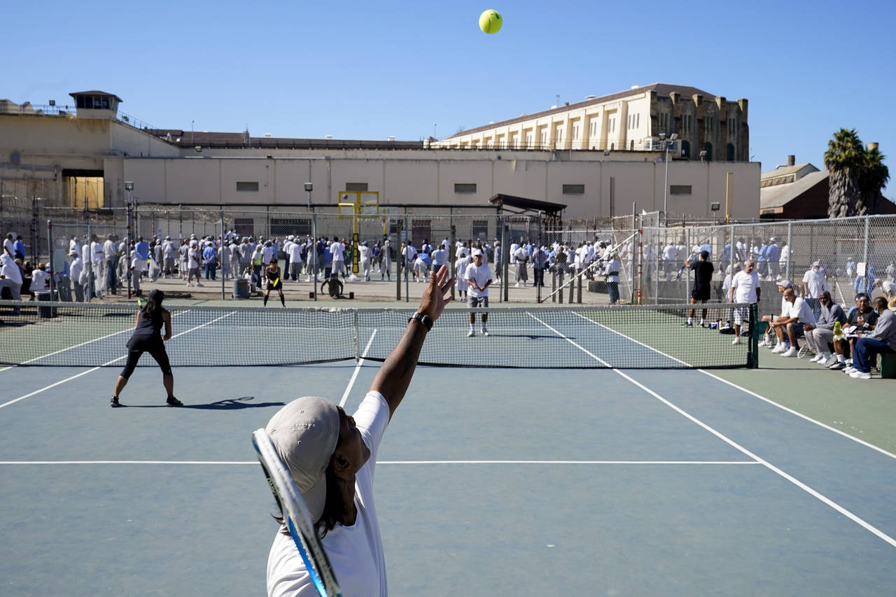 James Duff, bottom, serves during a tennis match between fellow San Quentin State Prison inmates an...