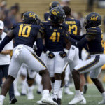 
              California cornerback Isaiah Young (41) celebrates with linebacker Femi Oladejo (10) and Collin Gamble (21) after intercepting the ball against UNLV during the second half of an NCAA college football game in Berkeley, Calif., Saturday, Sept. 10, 2022. (AP Photo/Jed Jacobsohn)
            