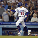 
              Los Angeles Dodgers' Mookie Betts points to the dugout as he reaches home plate on a three-run home run during the fourth inning of the team's baseball game against the San Diego Padres on Saturday, Sept. 3, 2022, in Los Angeles. (AP Photo/Marcio Jose Sanchez)
            