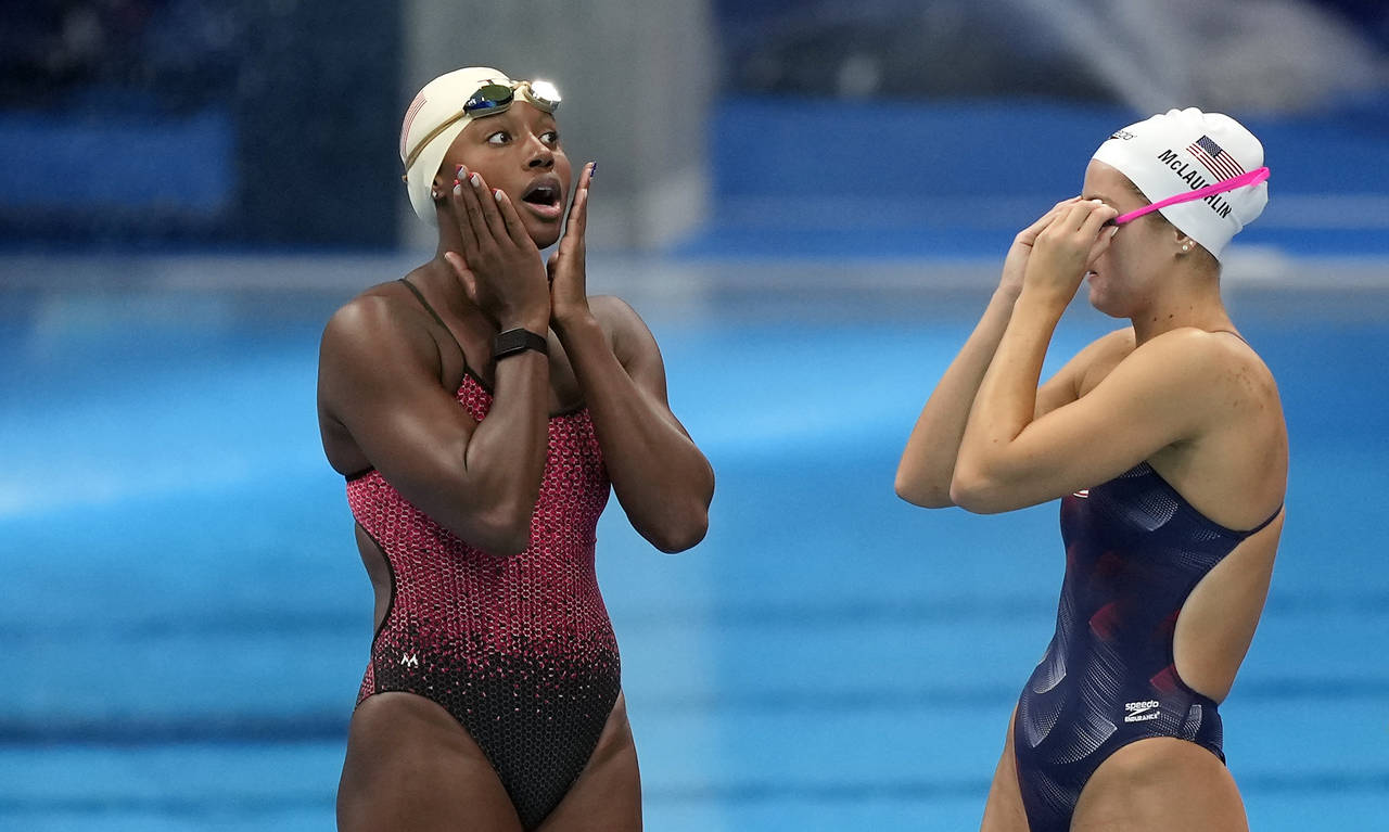 FILE - Simone Manuel of the United States, left, reacts with teammate Katie McLaughlin, right, at t...