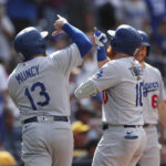 
              Los Angeles Dodgers' Justin Turner, front right, celebrates with Max Muncy (13) after hitting a grand slam against the San Diego Padres in the seventh inning of a baseball game Sunday, Sept. 11, 2022, in San Diego. (AP Photo/Derrick Tuskan)
            