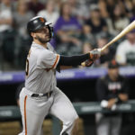 
              San Francisco Giants' David Villar follows the flight of his RBI-double off Colorado Rockies relief pitcher Justin Lawrence in the ninth inning of a baseball game Monday, Sept. 19, 2022, in Denver. (AP Photo/David Zalubowski)
            