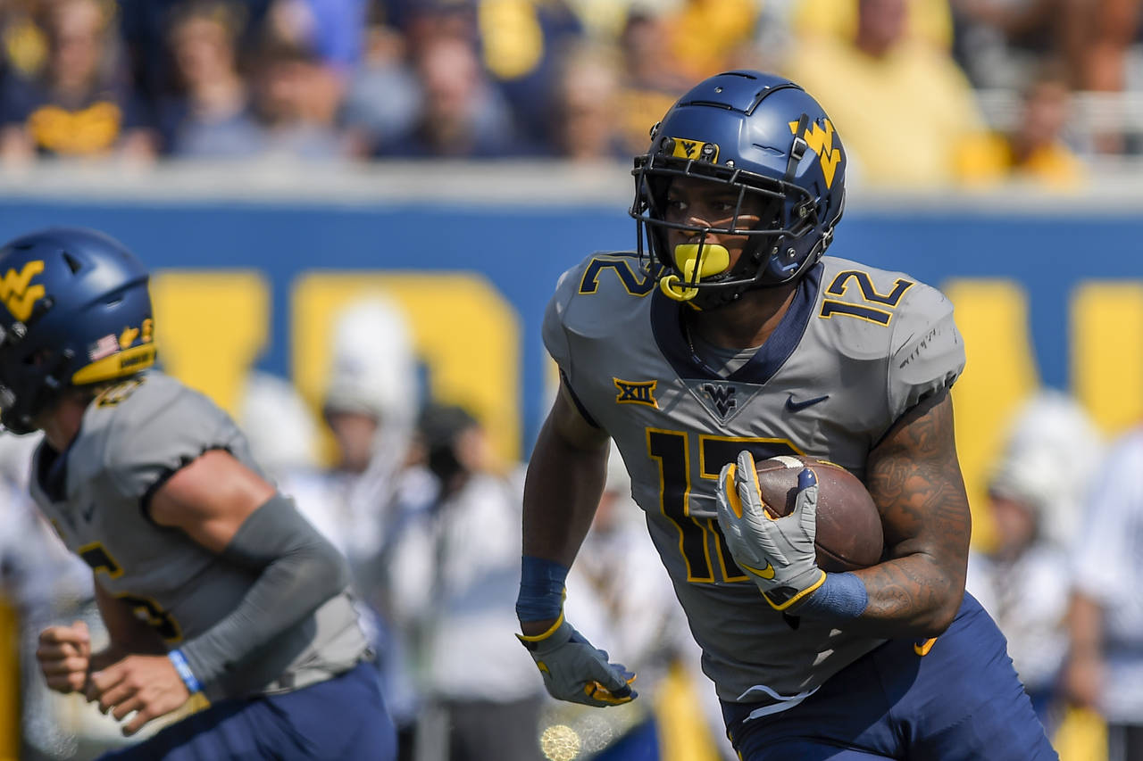 West Virginia running back CJ Donaldson (12) rushes the ball against Towson during the first half o...