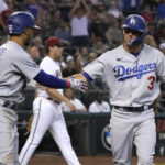 
              Los Angeles Dodgers' Chris Taylor (3) celebrates with Mookie Betts after scoring a run on a ball hit by Cody Bellinger (35) in the seventh inning during a baseball game against the Arizona Diamondbacks, Monday, Sept. 12, 2022, in Phoenix. (AP Photo/Rick Scuteri)
            