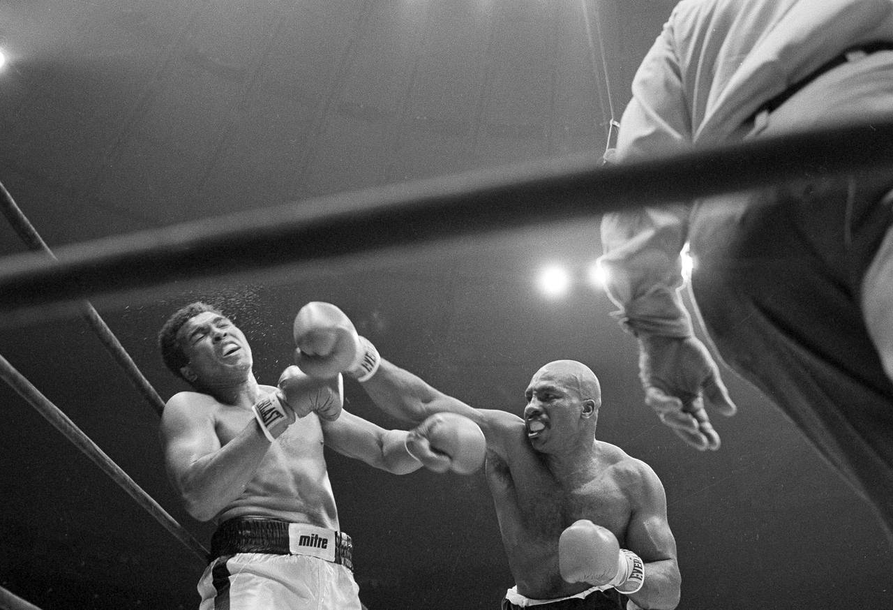 FILE - Challenger Earnie Shavers, right, follows through with a right against champion Muhammad Ali...